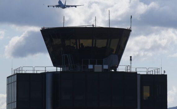 airplane takeoff over geneva airport control tower
